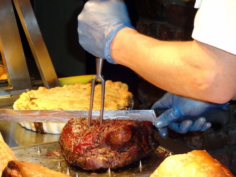 Chef carving roast beef and other meats at a buffet carvery stock photo                   