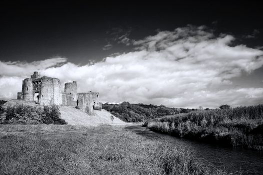 Kidwelly Castle Carmarthenshire Wales,  UK by the River Gwendraeth is an ancient architecture ruin of a 13th century medieval fort and a popular landmark travel destination black and white monochrome image stock photo
