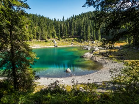 The Karersee below the Karerpass at the foot of the Latemar massif in South Tyrol, Italy