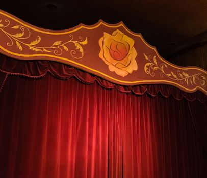 Stage with red curtains and a yellow rose. stage for shows