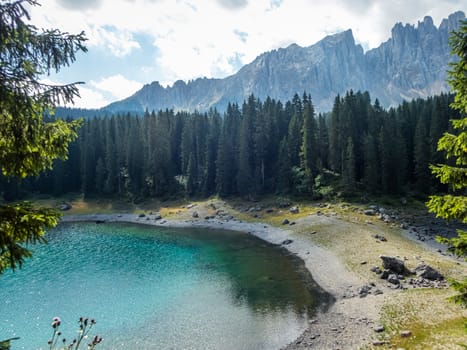 The Karersee below the Karerpass at the foot of the Latemar massif in South Tyrol, Italy