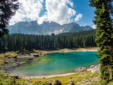 The Karersee below the Karerpass at the foot of the Latemar massif in South Tyrol, Italy