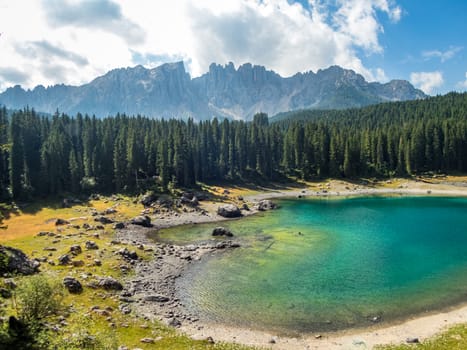 The Karersee below the Karerpass at the foot of the Latemar massif in South Tyrol, Italy