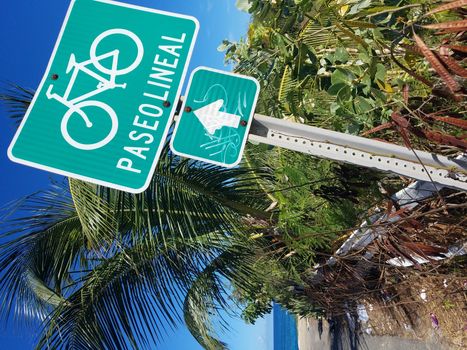 sand and ocean water and paseo lineal or biking or walking trail sign in Isabela, Puerto Rico