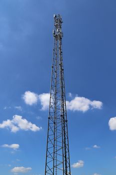 Electric antenna and communication transmitter tower in a european landscape against a blue sky