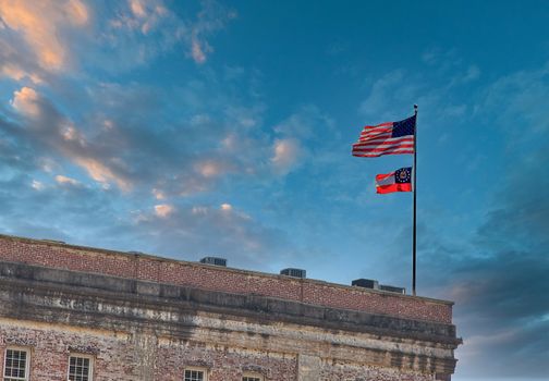 American and Georgia Flag flying over an old brick building