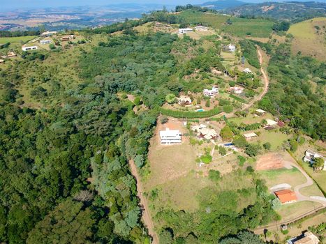 Aerial View of green scenic forest and land in the mountain in tropical country. Aerial view of forest to make with farm field and villa. Green area in the forest with lake