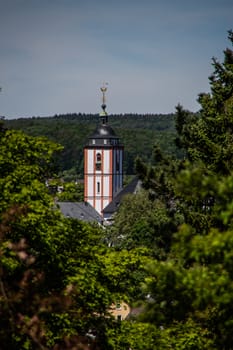 Church tower looks out between the trees