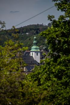 Church tower looks out between the trees