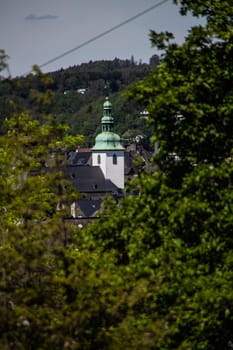 Church tower looks out between the trees