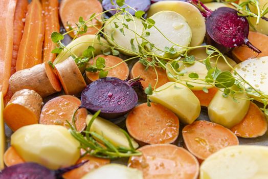 Cut raw vegetables before putting them in the oven. Carrots, potatoes, sweet potatoes, beets, kohlrabi, rosemary, garlic, hyssop