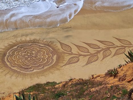 Mandalas drawn in the sand by Vitor Raposo at Praia Maria Luisa in Albufeira in Portugal