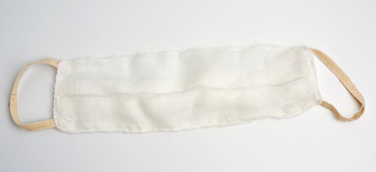 reusable mask of white cotton gauze on a white background, homemade remedy for viral diseases, top view, concept eco-friendly, zero waste 