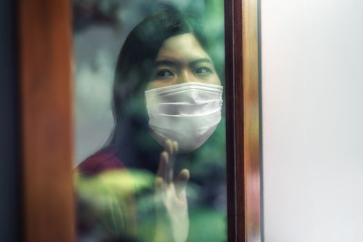 Asian woman wearing medical mask stay isolation at home for self quarantine in  Covid-19 outbreak situation, coronavirus pandemic and lockdown, Social distancing and responsibility, new normal concept