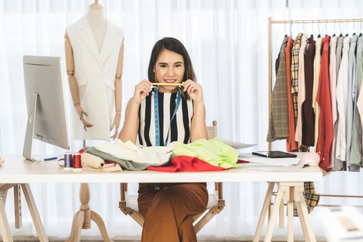 Portrait of Young Asian designer woman working and choosing multicolor clothes at workplace,small business startup, Business owner entrepreneur, modern freelance job lifestyle concept. asia people