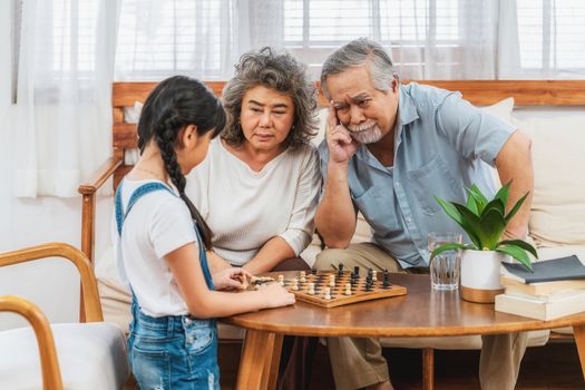 Asian couple Grandparent with grandchild playing the chess with Use thought together, support and success, Long live and Elderly society,Warm family and happiness,social distancing concept