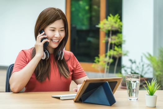 Asian business woman using mobile phone with keyboard and calling for working from home in outdoor home and garden, startups and business owner, social distance and self responsibility