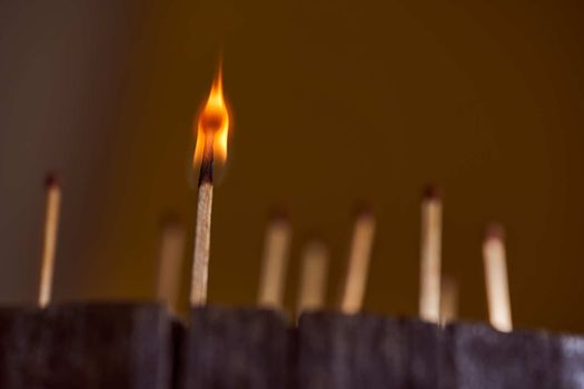 One burning match. wooden matches are on the wooden frame. High quality photo