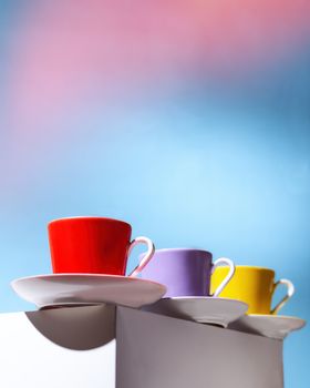 Violet, Yellow and red cup for coffee stand on a white cube. High quality photo