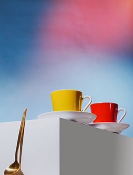 Yellow and red cup for coffee stand on a white cube. High quality photo