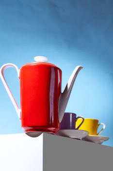 Red coffee teapot and two cup for coffee shop stand on a white cube. High quality photo