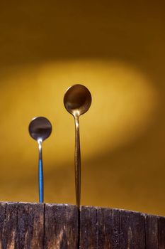 Golden Spoons standing on wooden frame. yellow background. High quality photo
