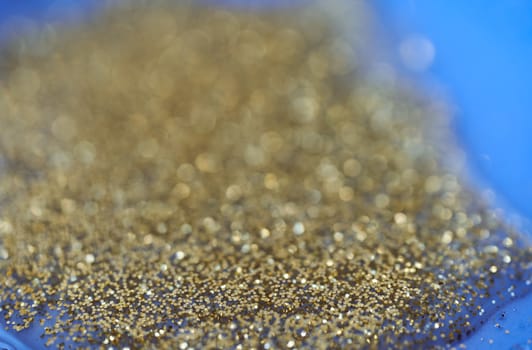 Gold glitter on a dark blue background. blur effect. High quality photo