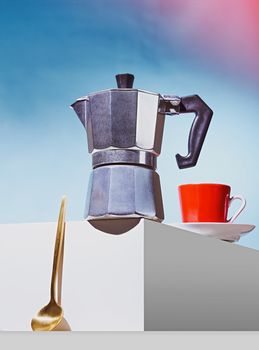 Geyser coffee maker, golden spoon and red cup for coffee shop stand on a white cube. High quality photo