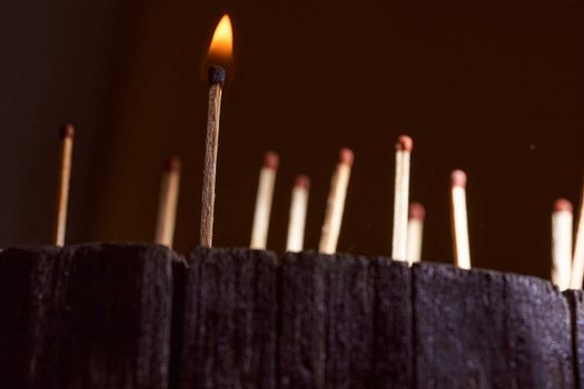 One burning match. wooden matches are on the wooden frame. High quality photo