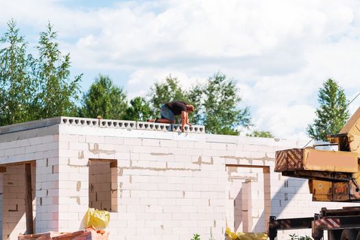 Builder worker installing concrete floor slab panel at building construction site. Second floor house concrete floor slab installation