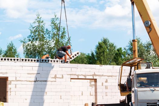 Builder worker installing concrete floor slab panel at building construction site. Second floor house concrete floor slab installation