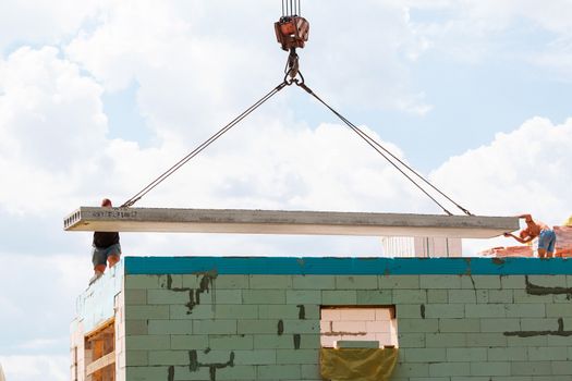 Builder worker installing concrete floor slab panel at building construction site. Second floor house concrete floor slab installation