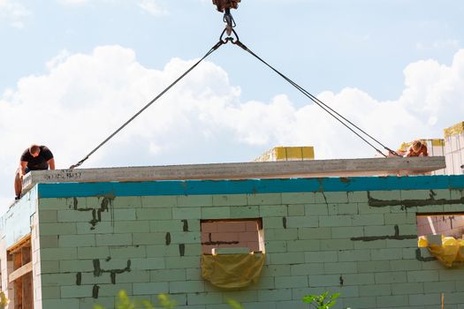 Builder worker installing concrete floor slab panel at building construction site. Second floor house concrete floor slab installation