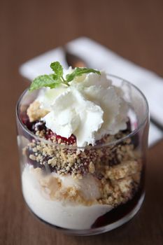 Vanilla ice cream with blue berry topping on wood background