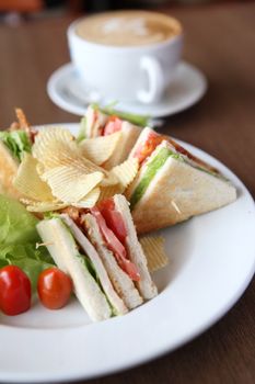 Club sandwich with coffee on wood background