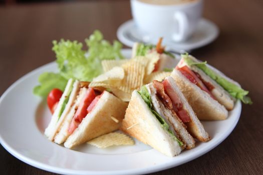 Club sandwich with coffee on wood background