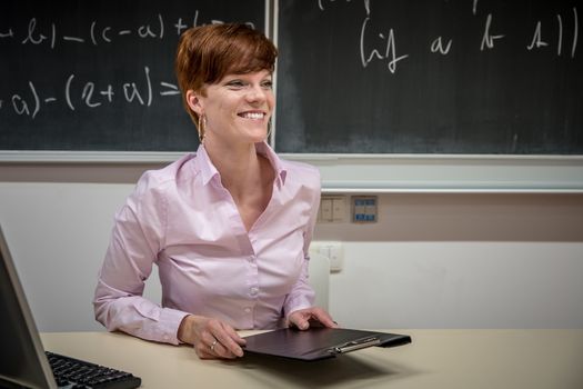 teacher lectures at the School of Mathematics, writes chalk on a blackboard