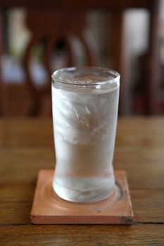 Glass with water on wood background 
