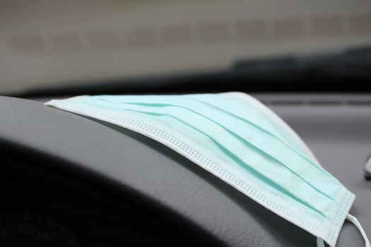 Mouth protection lying on the dashboard inthe car