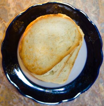 slices of baked bread on a white and white plate, background - light textured marble