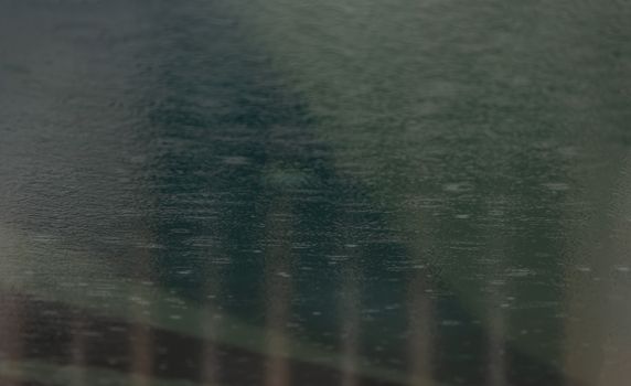 Rain drops falling in the swimming pool. Water surface for background and abstract.