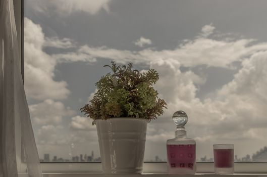 Relaxing area by the window with city view. Enjoy relaxing moment with grape juice and flower. City view, Copy space. Selective focus.