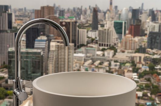 Modern hygienic hand basin with cityscape that can look outside from big window. Elegant faucets and components, Sanitary ware, The concept of health care. Selective focus.