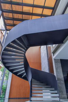 Side view of a spiral staircase pattern. Spiral stairs circle in courtyard architecture. Outdoor ladder decoration interior. Selective focus.