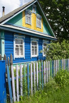 Traditional village house in Belarus. Windows with carved shutters and curtains. Vertical image
