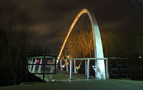 a pedestrian footbridge crossing the river aire in leeds illuminated at night