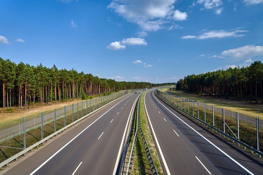 A two-lane asphalt expressway crossing the forest in Poland