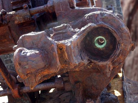 close up of a large rusting broken industrial engine with bolts and gears outdoors