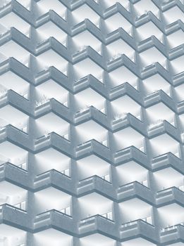 an abstract blue duotone image of large residential highrise building with geometric rows of balconies
