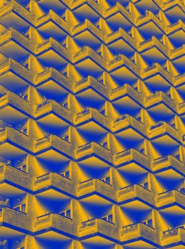 an abstract duotone yellow and blue image of large residential highrise building with geometric rows of balconies